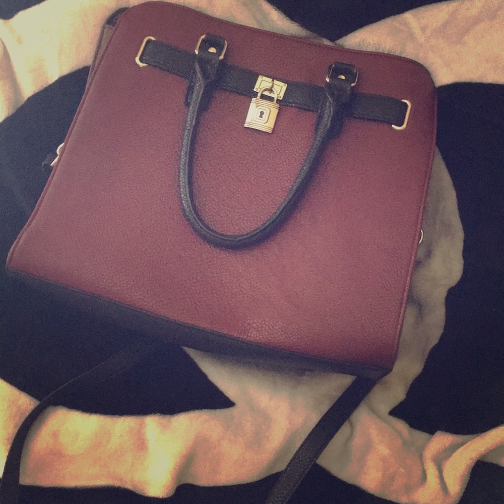 Maroon handbag with handles and shoulder strap